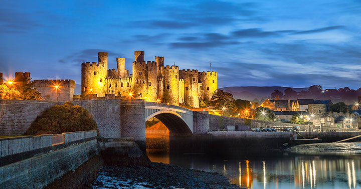 conway castle and village all lit up at night
