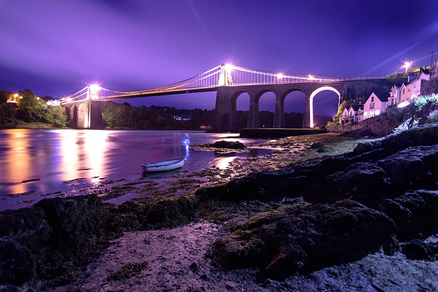 meani bridge view all lit up at night and seen from the shore